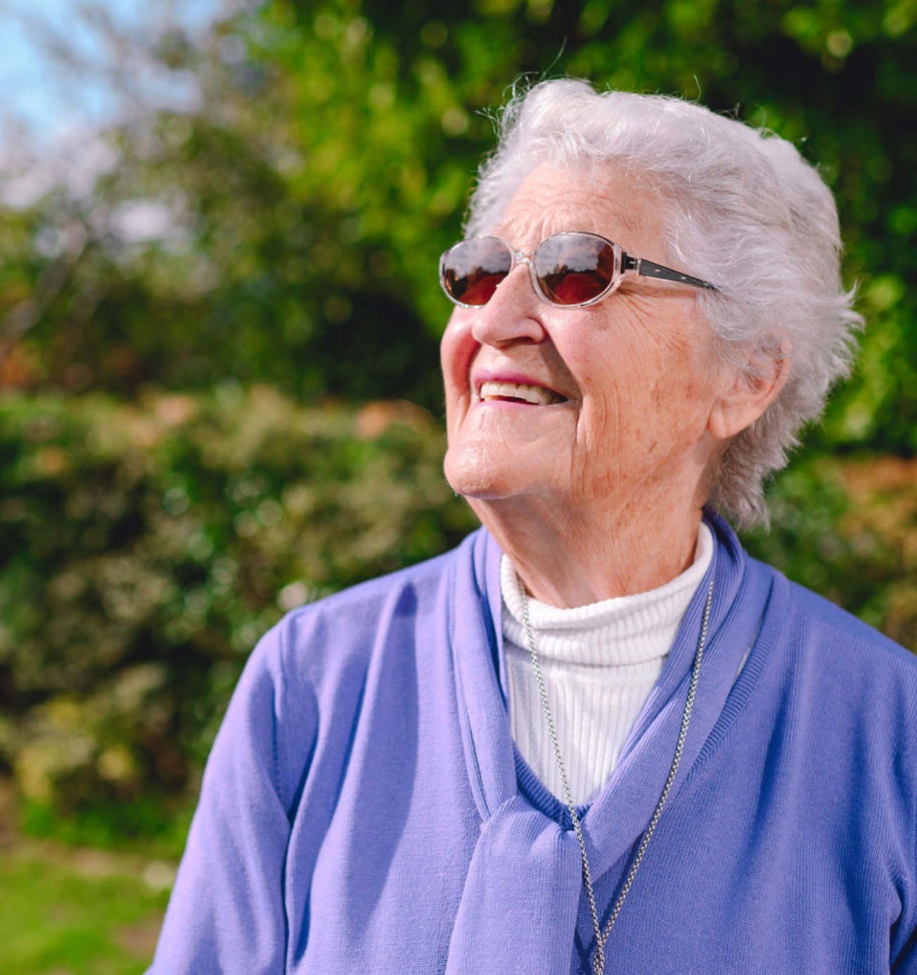 Smiling elderly woman enjoying the outdoors in Brighton.