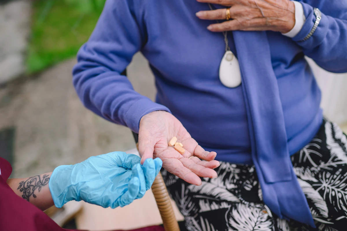 Nestwell home care assistant helping an elderly woman with medication management as part of her care package.