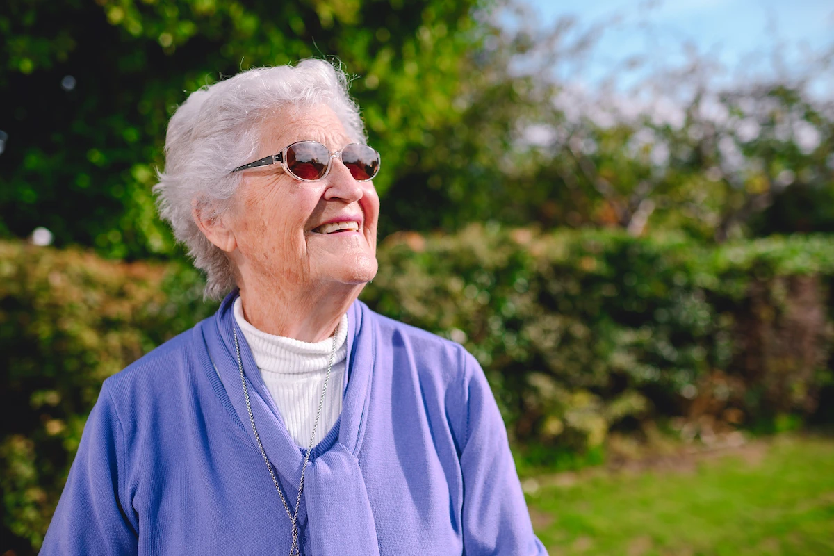 Smiling elderly woman enjoying the outdoors in Brighton.